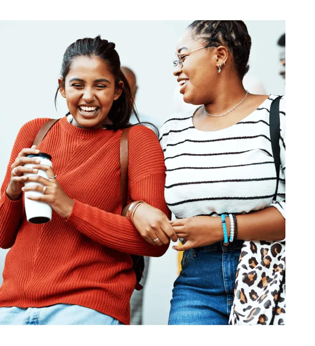 Two cheerful friends locking in arms and happily laughing